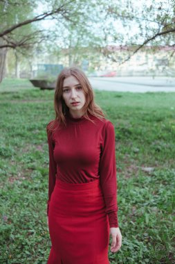 Kırmızılı gizemli kız ormanda yürüyor.