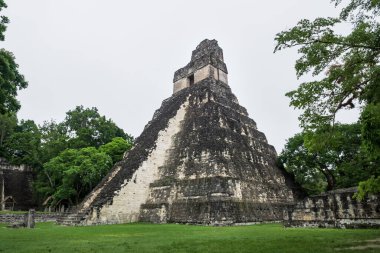 Santa Pedro la Laguna, Guatemala - 23 Nisan 2018: Atitlan Gölü kıyısındaki geleneksel balıkçı kanoları, gün batımında sisli volkanik dağlara bakan insanlarla balık tutmak