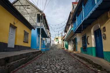 Flores, Peten, Guatemala 'da renkli boyanmış evleri olan Colonial kaldırım taşı caddesi.