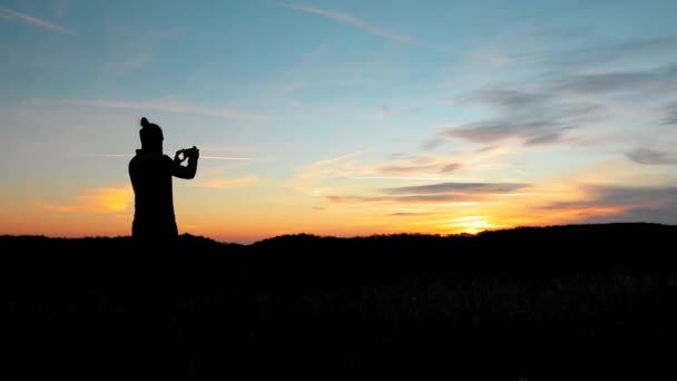Sylwetka Mężczyzny Robiącego Zdjęcia Telefonem Podczas Jesiennego Zachodu Słońca — Wideo stockowe