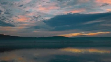 Güz boyunca renkli bulutların yansımasıyla gölün doğuşunda çarpıcı bir zaman atlaması