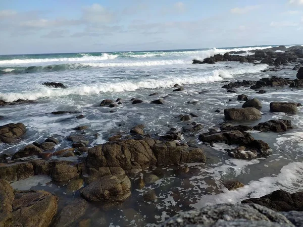 Dalgalar kıyıdaki kayalara çarpıyor.