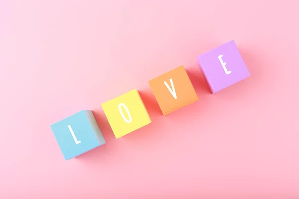 Wortliebe Geschrieben Auf Bunte Spielzeugwürfel Vor Leuchtend Rosa Hintergrund Mit — Stockfoto