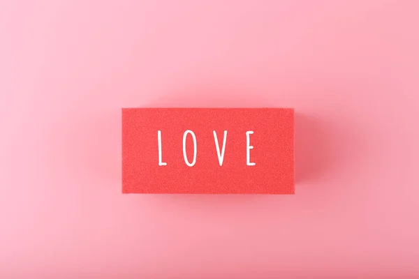 Word Liefde Geschreven Rode Rechthoek Tegen Roze Achtergrond Met Kopieerruimte — Stockfoto