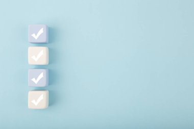 Parlak pastel mavi arkaplanda fotokopi alanı ile dört kontrol işareti. Sorgulama, kontrol listesi, liste, planlama, iş ve doğrulama kavramı. Yaratıcı asgari bileşim 