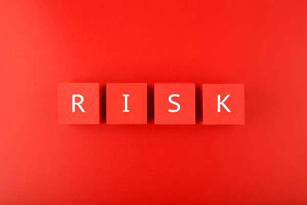 Risk single word written on red cubes against red background. Concept of risk and danger in business, social life, health, life style decisions or strategy