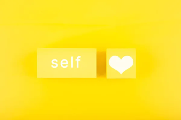 Trendy minimal self love creative concept in monochromatic yellow color. Mental health, self acceptance, self care and respect or being single concept.