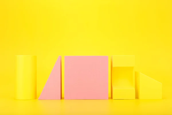 Abstracte futuristische achtergrond in gele en roze kleuren met kopieerruimte. Verschillende geometrische figuren op een rij — Stockfoto