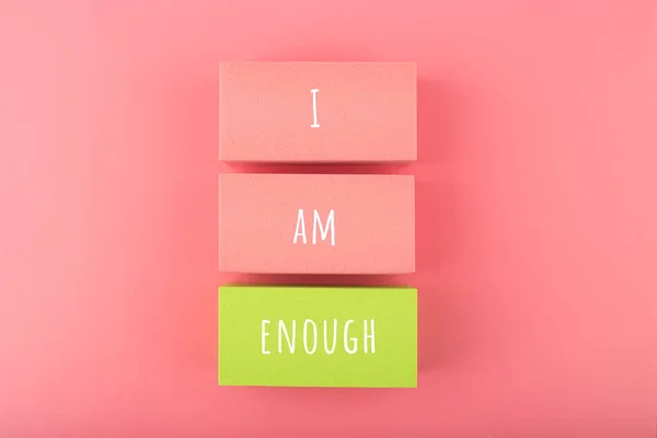 I am enough concept with words written on colorful rectangles against bright pink background. Self love concept — Fotografia de Stock