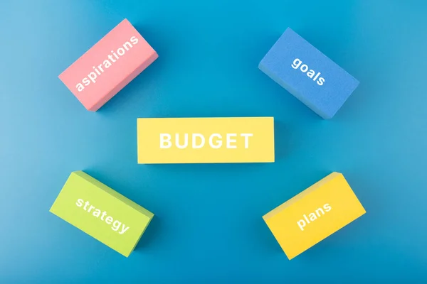 Концепція бюджетного планування. Бюджет тексту, план, цілі, прагнення, написані на кольорових прямокутниках на синьому фоні — стокове фото