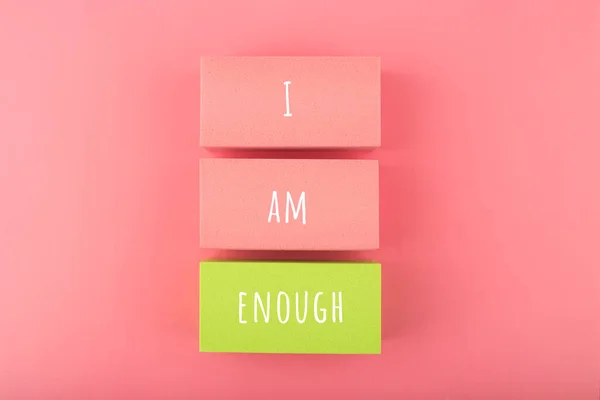 I am enough concept with words written on colorful rectangles against bright pink background. Self love concept Royalty Free Stock Fotografie