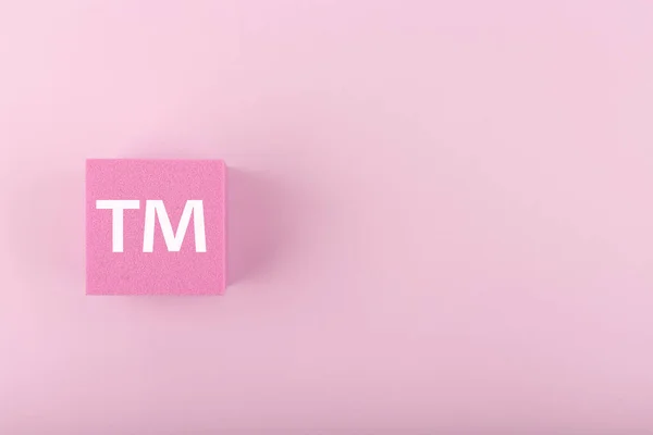 TM товарний знак на рожевому фоні з копіювальним простором. — стокове фото