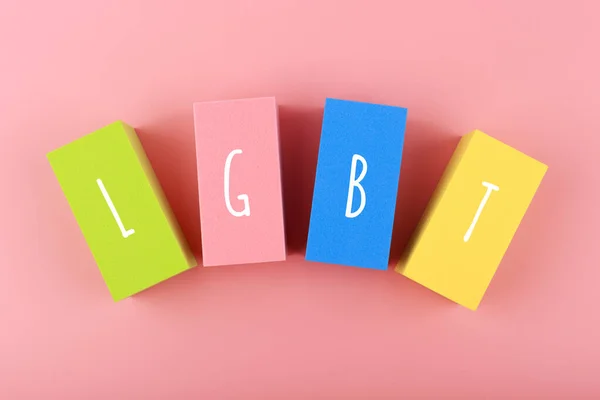 Lgbt letters on multicolored rectangular geometric figures on pink background. Imagens Royalty-Free