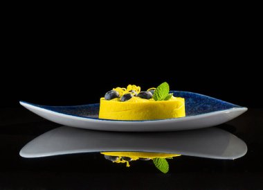 Yellow light dessert on a black background with reflection