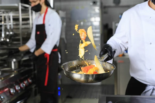 Joven Chef Masculino Volteando Verduras Wok Cocina Comercial — Foto de Stock