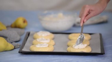 Krem peynirli ve armutlu çörek yapan bir kadın..