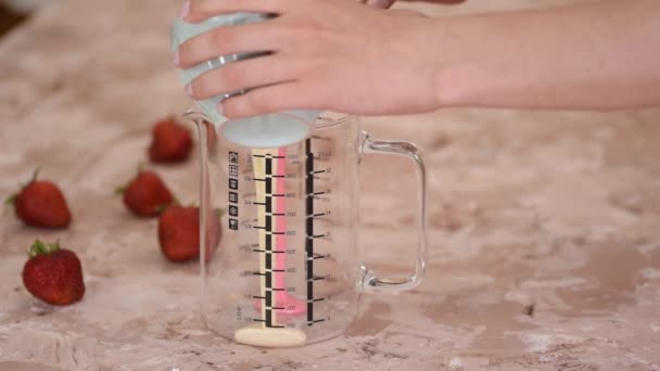 女性パティシエがピンクと白の鏡の釉薬をガラス瓶に組み合わせ — ストック動画