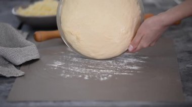 Kadın fırıncı masaya yumuşak hamur koyuyor