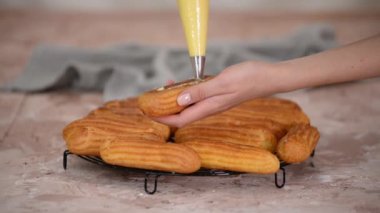 Pasta şefi eklerleri pasta poşetindeki kremlerle doldurur..