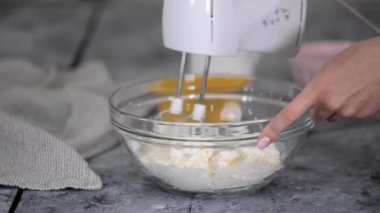 Kadın kremayı karıştırma makinesiyle dövüyor.