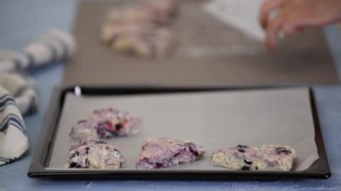 Ev hanımı mutfakta yaban mersinli İngiliz çöreği yapıyor..