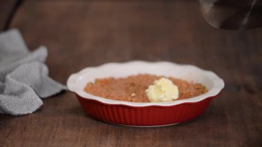 Kadın çoban turtası yapıyor. Patates püresi kıymanın üstüne konuyor..