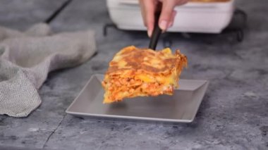 Gri tabakta lezzetli bir lazanya parçası. Ev yapımı et lazanyası. İtalyan Geleneksel Yemekleri.