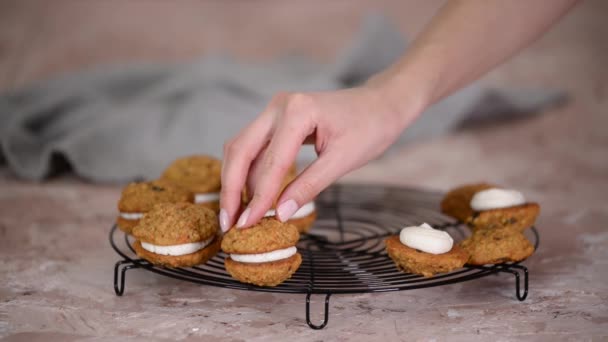 Pastelero haciendo galletas sándwich con relleno de queso crema. — Vídeos de Stock