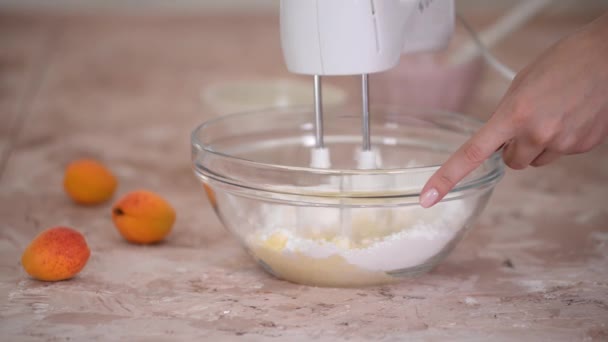 Bicie masła cukrem pudrem w szklanej misce za pomocą miksera elektrycznego. — Wideo stockowe