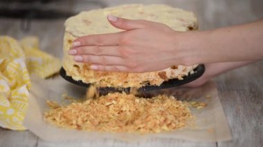 Pasta şefi Napolyon keki yapıyor. Napolyon pastasını ufalanmış bisküvilerle kaplamak
