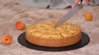 Kayısı kısayol turtası kesen bir kadın. Taze kayısı turtası..