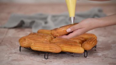 Ekini choux kremiyle dolduran şekerleme çantalı bir şef..