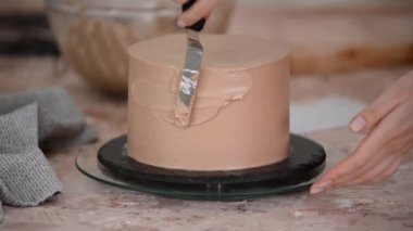 Pasta Şefi Kadın, Sünger Pastası 'na çikolatalı krema sürüyor..