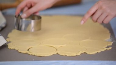 Genç kadın hamur çemberleri çiziyor..