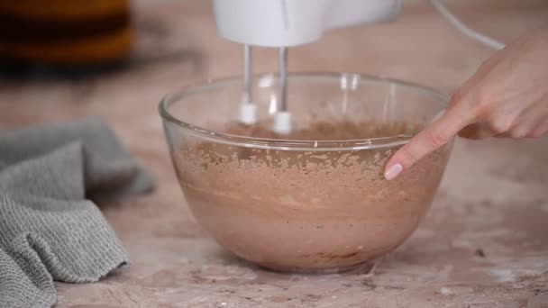 Mistura de creme de chocolate para bolo com misturador elétrico. — Vídeo de Stock
