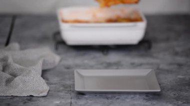 Gri arka planda Bachamel soslu ev yapımı İtalyan lazanyası. Peynirli sıcak lazanya..