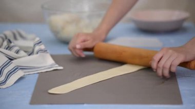 Fırıncı hamur yuvarlıyor. Pastane için el yapımı pasta..