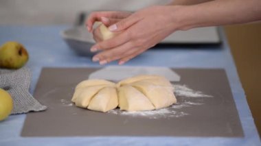 Yakın çekim eller çörek pişirmek için hamur topları oluşturuyor..