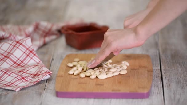 Cutting almonds on a wood board. — ストック動画