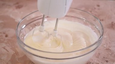 Aşçı kız çırpılmış yumurta beyazına yumurta sarısı ekleyip karıştırıyor..