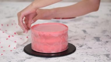 Pasta şefi ahududulu kremalı pasta hazırlıyor. Yan pastayı pembe çikolatayla süsleyin.