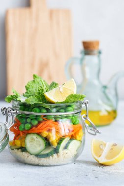Taze çiğ sebze ve kuskus dilimli cam kavanoz. Sağlıklı Yemek Hazırlama - tarif hazırlama fotoğrafları. Cam kaplarda sağlıklı vejetaryen yemekleri. Kilo kaybı gıda konsepti. Kavanozda ev yapımı salata.. 