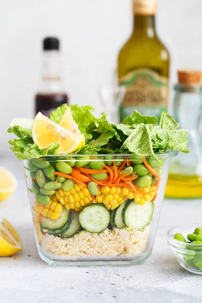 Taze çiğ sebze salatasıyla dolu cam kutu. Sağlıklı yemek tarifi hazırlama. Cam kapta sağlıklı vejetaryen yemeği. Vejetaryen mutfağı. Bitki bazlı yemekler. Yeşil yaşam konsepti. Organik doğal yiyecekler.. 