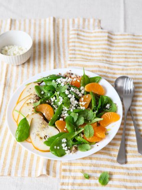 Armut, portakal ve ricotta ile ıspanak ve kinoa salatası. Sağlıklı yemek hazırlığı. Bitki bazlı yemekler. Yeşil yaşam. Vejetaryen tarifi. Yemek tasarımı. Vejetaryen mutfağı. Sağlıklı beslenme. Kilo kaybı gıda konsepti.