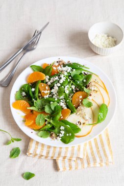 Armut, portakal ve ricotta ile ıspanak ve kinoa salatası. Sağlıklı yemek hazırlığı. Bitki bazlı yemekler. Yeşil yaşam. Vejetaryen tarifi. Yemek tasarımı. Vejetaryen mutfağı. Sağlıklı beslenme. Kilo kaybı gıda konsepti.