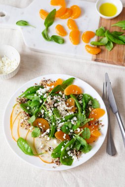 Armut, portakal ve ricotta ile ıspanak ve kinoa salatası. Sağlıklı yemek hazırlığı. Bitki bazlı yemekler. Yeşil yaşam. Vejetaryen tarifi. Yemek tasarımı. Vejetaryen mutfağı. Sağlıklı beslenme. Kilo kaybı gıda konsepti.