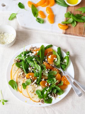 Armut, portakal ve ricotta ile ıspanak ve kinoa salatası. Sağlıklı yemek hazırlığı. Bitki bazlı yemekler. Yeşil yaşam. Vejetaryen tarifi. Yemek tasarımı. Vejetaryen mutfağı. Sağlıklı beslenme. Kilo kaybı gıda konsepti.