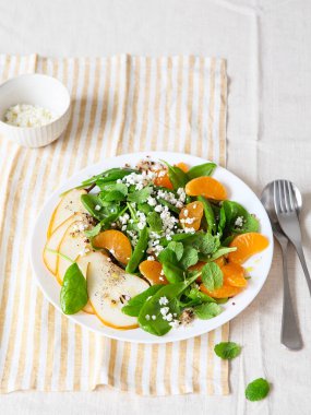 Armut, portakal ve ricotta ile ıspanak ve kinoa salatası. Sağlıklı yemek hazırlığı. Bitki bazlı yemekler. Yeşil yaşam. Vejetaryen tarifi. Yemek tasarımı. Vejetaryen mutfağı. Sağlıklı beslenme. Kilo kaybı gıda konsepti.