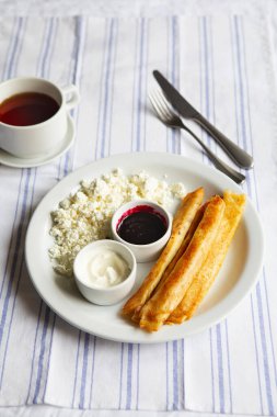 Kızarmış Gözleme Blintzler. Süzme peynirli, ekşi kremalı ve reçelli Rus krepleri. Sağlıklı geleneksel kahvaltı. Doldurulmuş lezzetli krepler. Çocuk menüsü.