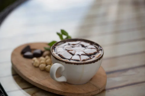 Fındıklar masada bir fincan kapuçinonun yanında.